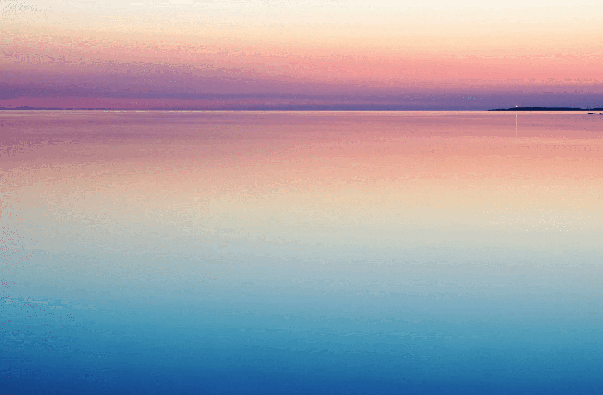The sea with the colours of the sunset reflecting in the calm water